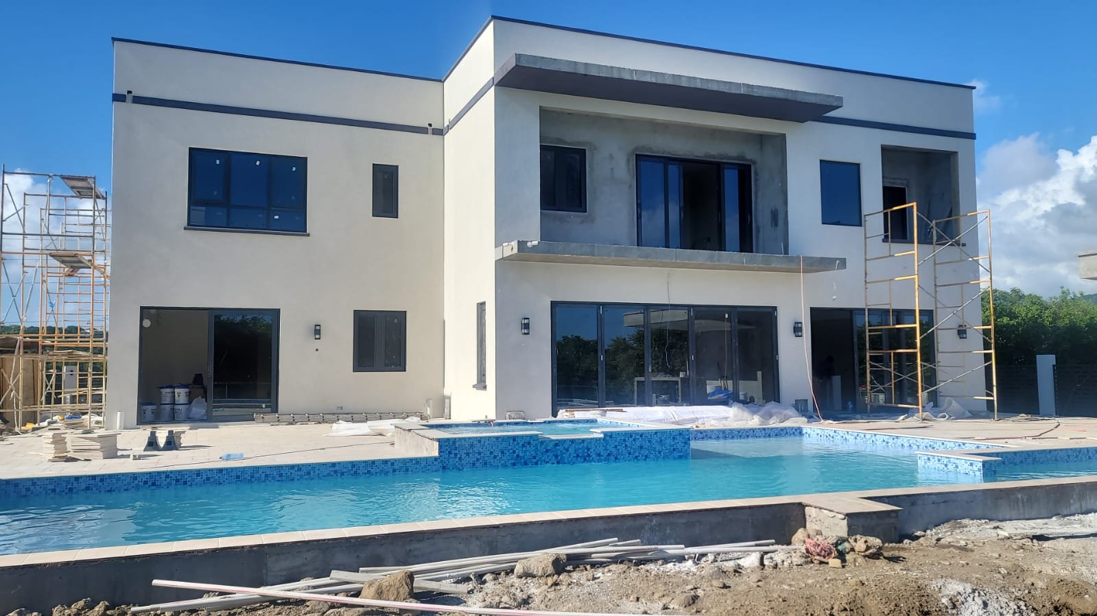 WANSLEY whole-home aluminum windows and doors installed in South Africa; scaffolding and other ongoing building work remain visible